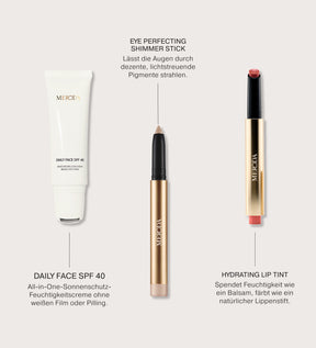 Sunkissed Trio mit Daily Face SPF 40, Eye Perfecting Shimmer Stick und Hydrating Lip Tint in elegantem Gold und Weiß.