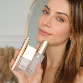 Das Travel Kit mit Mini Changing Foundation, Final Touch Setting Spray und Gilded Lashes Mascara, gehalten von einem Model