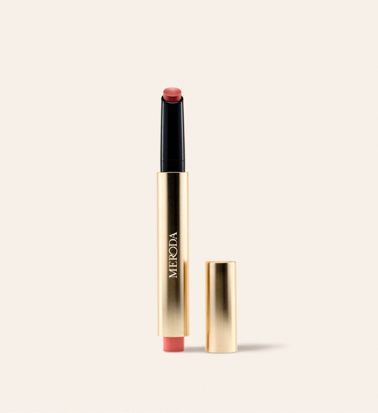 Hydrating Lip Tint im Farbton Peachy Rose als eleganter Klick-Stift in Gold mit passender Kappe daneben.