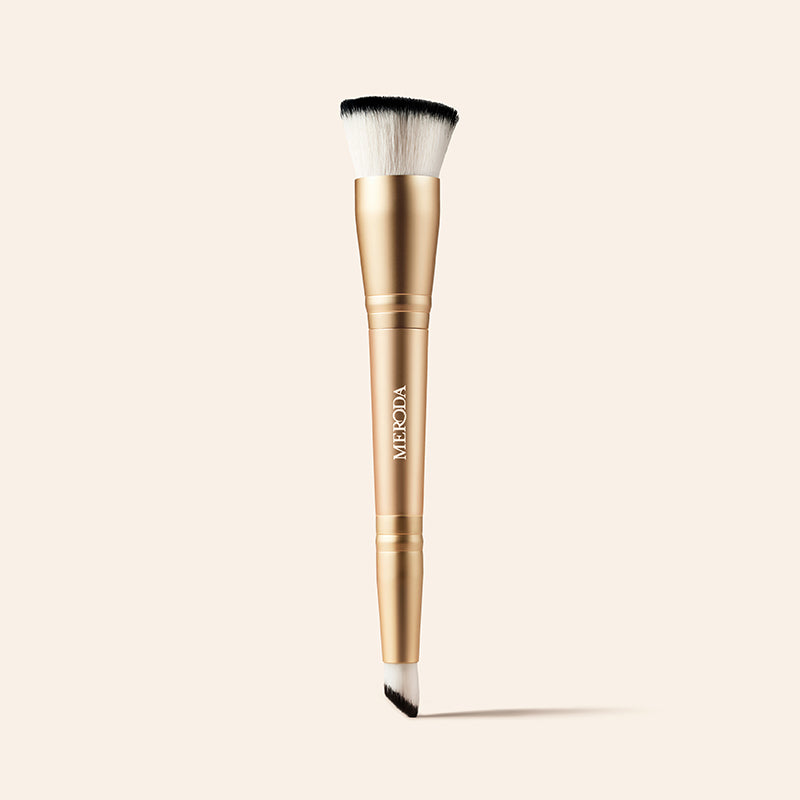 Meroda Cosmetics 2-in-1 Build & Conceal Brush mit goldenem Griff und zweiseitigen Borsten auf hellem Hintergrund