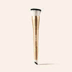 2-in-1 Build & Conceal Brush mit goldenem Griff und zweiseitigen Synthetikborsten auf neutralem Hintergrund.