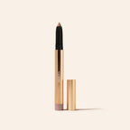 Eye Perfecting Shimmer Stick in Pearl mit schimmernder Spitze und eleganter Goldhülse auf Creme.