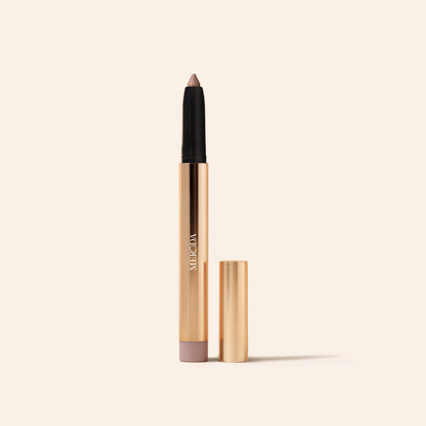 Eye Perfecting Shimmer Stick in Pearl mit schimmernder Spitze und eleganter Goldhülse auf Creme.