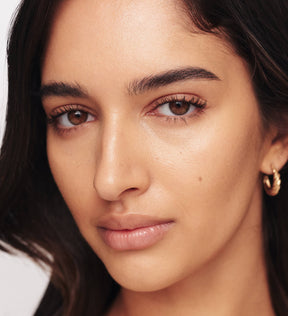 Nahaufnahme eines Models, das Meroda Gilded Lashes Mascara trägt und lange und definierte Wimpern zeigt