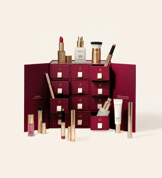 Festlicher maronifarbener Adventskalender mit 12 nummerierten Schubladen zeigt verschiedene Meroda Beauty-Produkte und einen Foundation-Pinsel.
