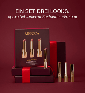 Mini Lip Tint Trio in goldener Verpackung auf dunklen Geschenkboxen mit roter Schleife.
